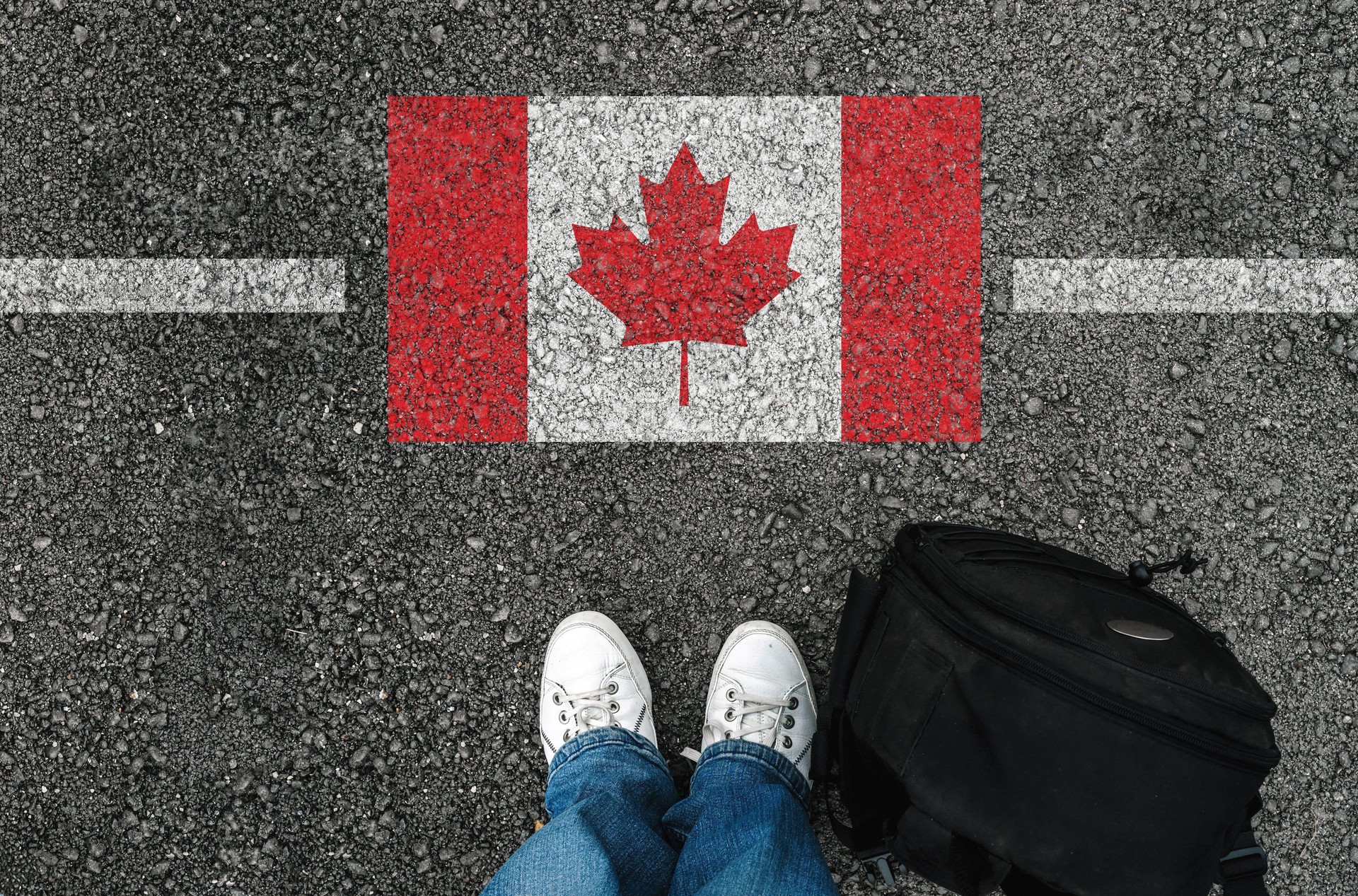 a man with a shoes is standing next to flag of Canada