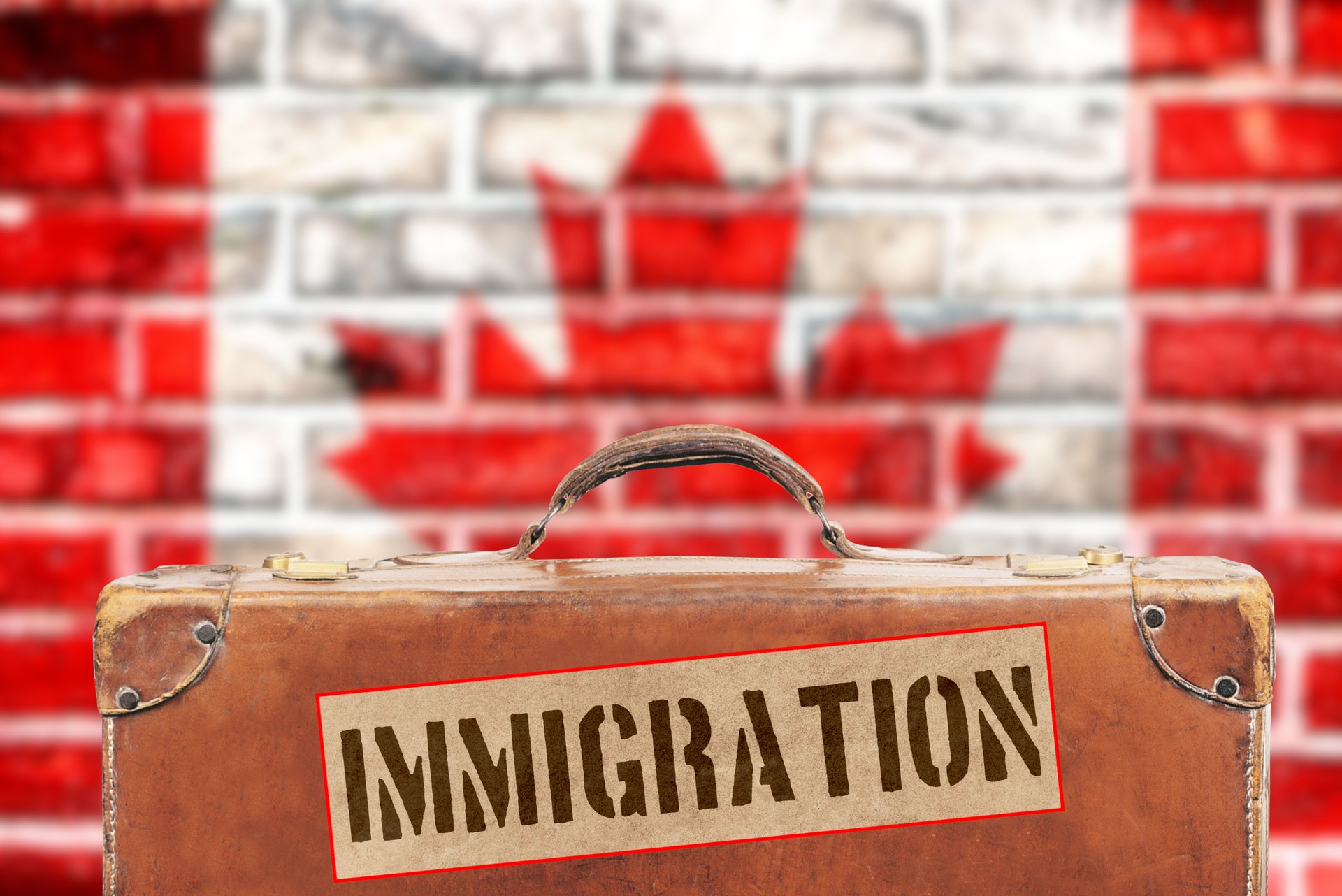 Flag of Canada and a suitcase with the sticker Immigration